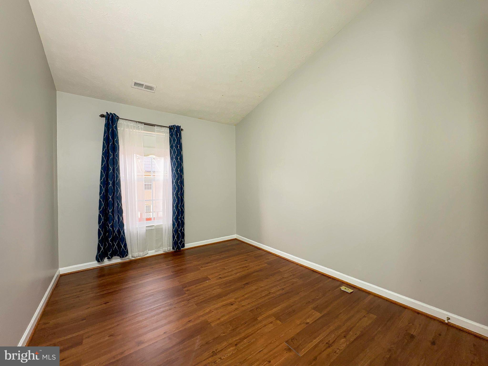 826 Lowe Road Baltimore, MD 21220 - Photo 8 of 35 an empty room with wooden floor and windows