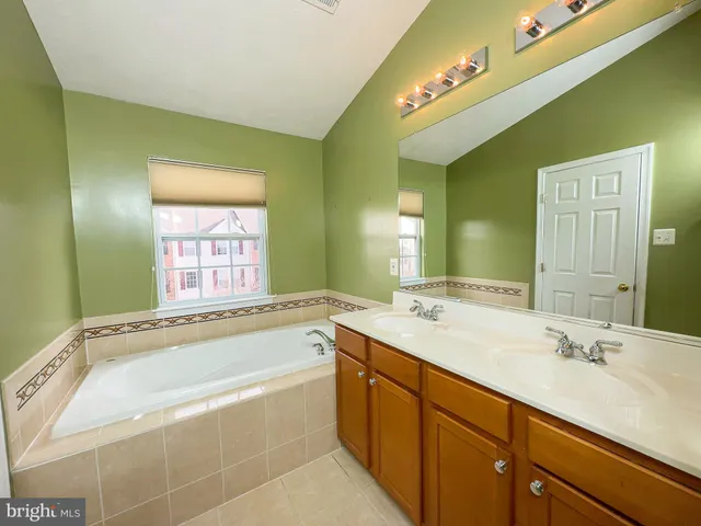 a bathroom with a tub sink and mirror