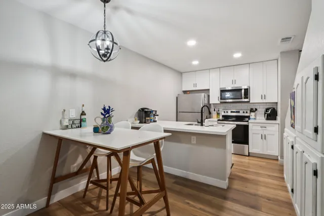 a kitchen with a center island white cabinets and stainless steel appliances