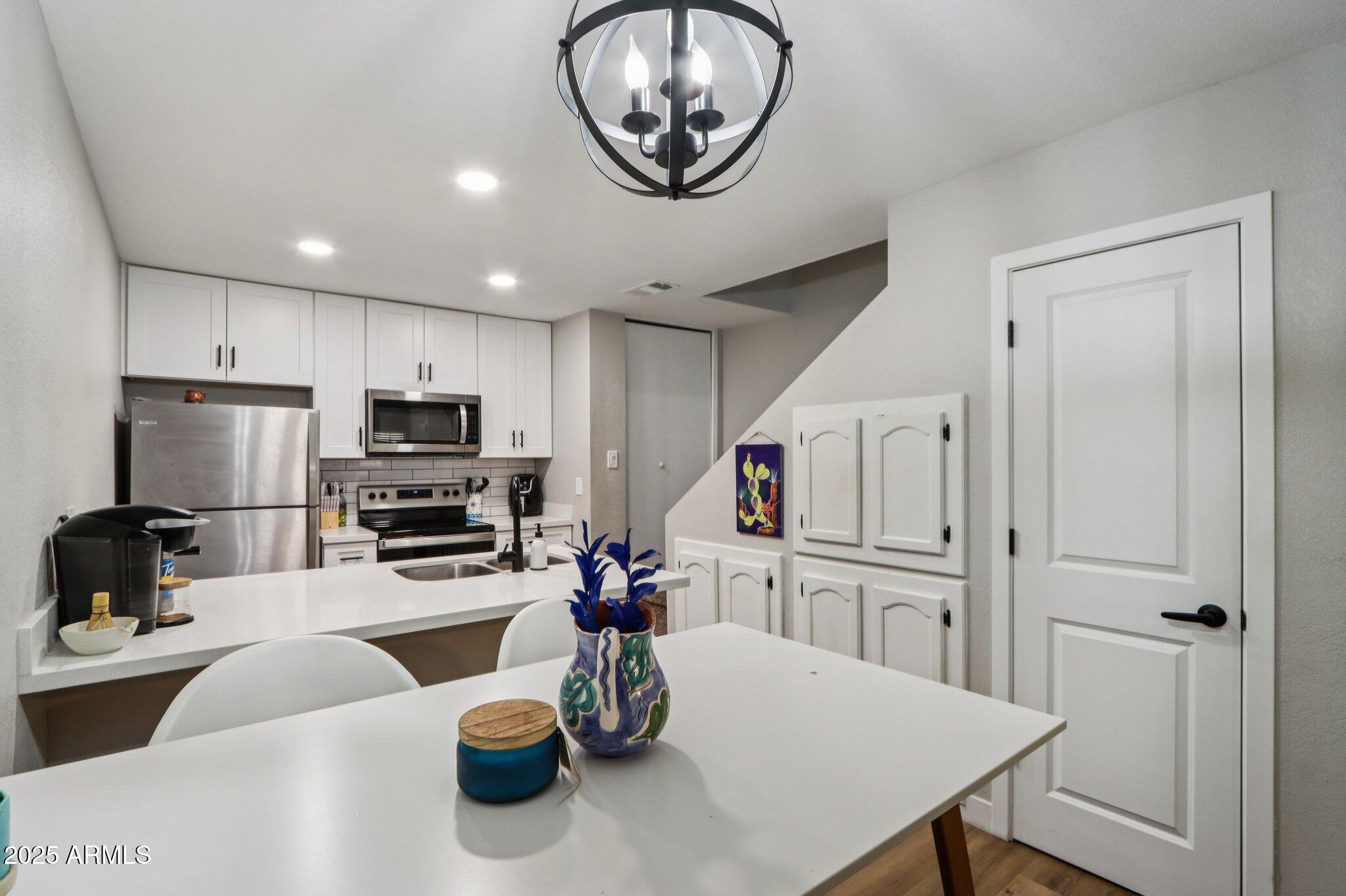 510 North Alma School Road, Unit 174 Mesa, AZ 85201 - Photo 12 of 38 a kitchen with a refrigerator a stove a microwave and cabinets
