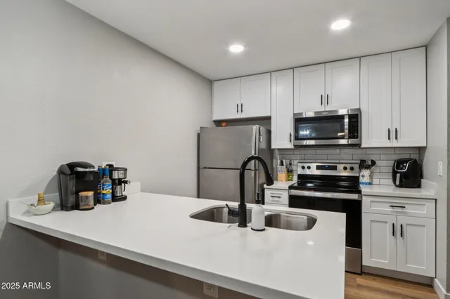 a kitchen with kitchen island a sink a stove and microwave