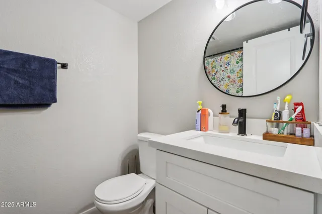 a bathroom with a toilet a sink and a mirror