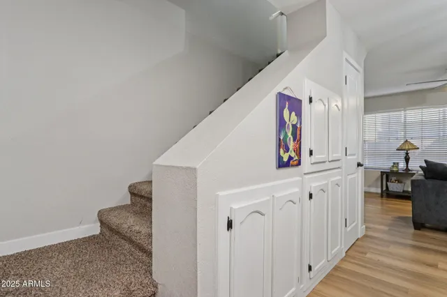 a hallway with white cabinets and wooden floor