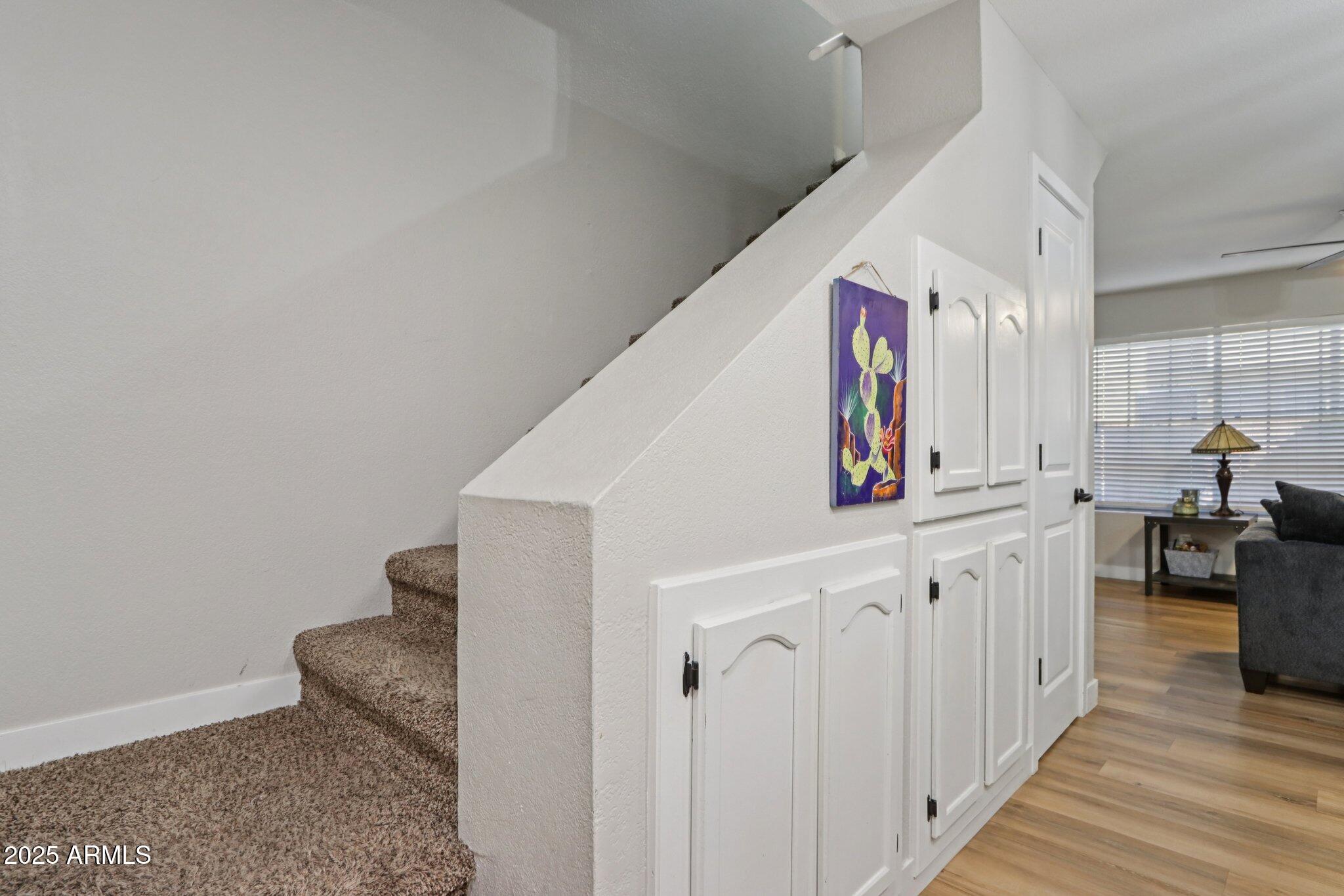 510 North Alma School Road, Unit 174 Mesa, AZ 85201 - Photo 8 of 38 a hallway with white cabinets and wooden floor