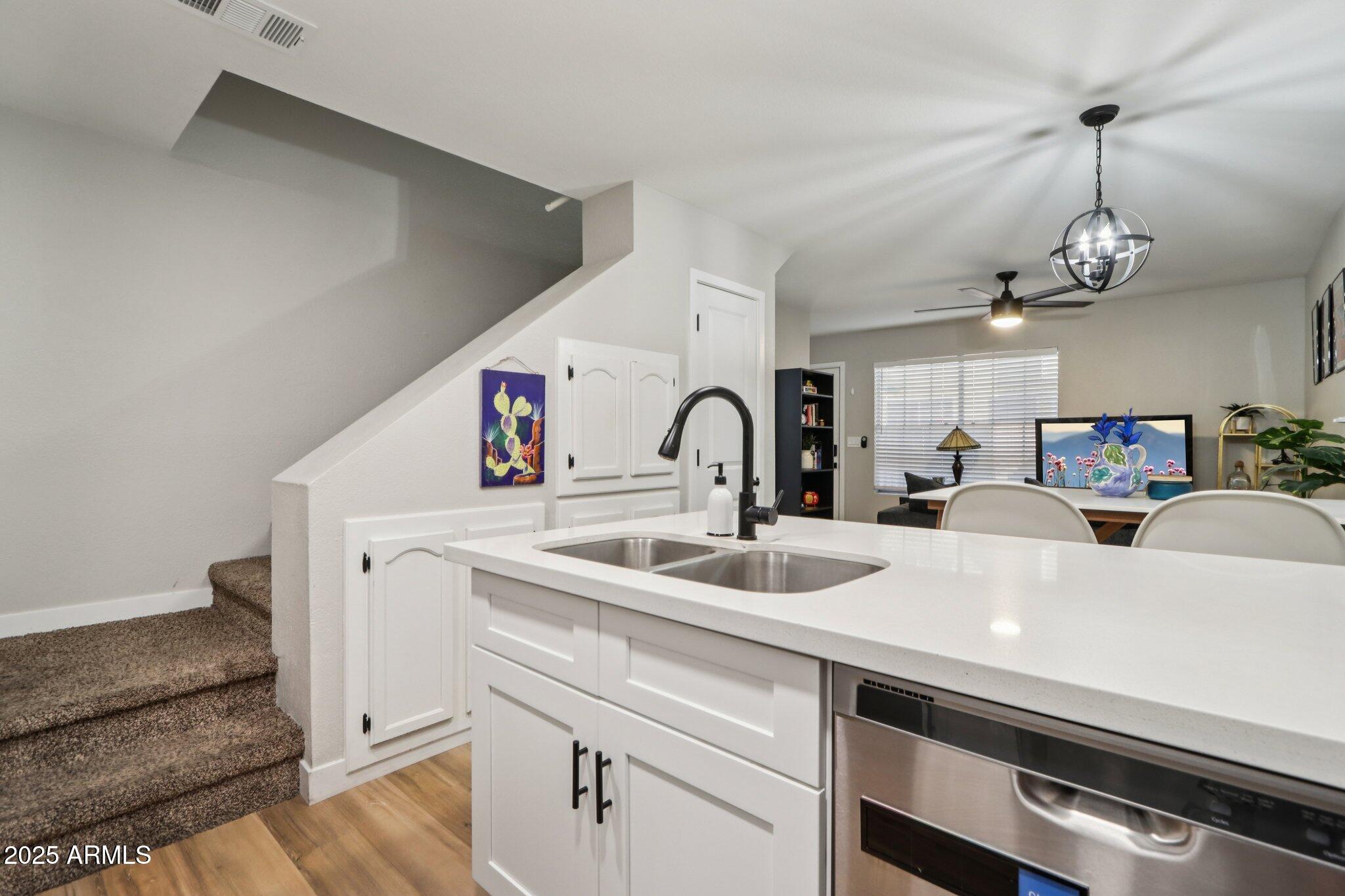 510 North Alma School Road, Unit 174 Mesa, AZ 85201 - Photo 9 of 38 a kitchen with a sink stainless steel appliances and chandelier