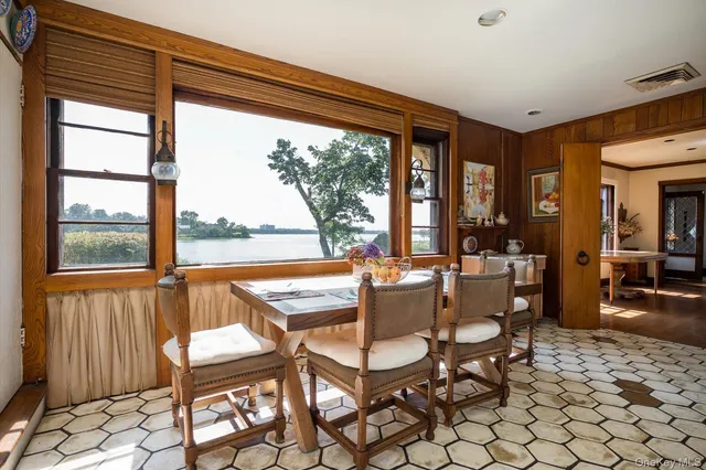 a dining room with furniture and large windows