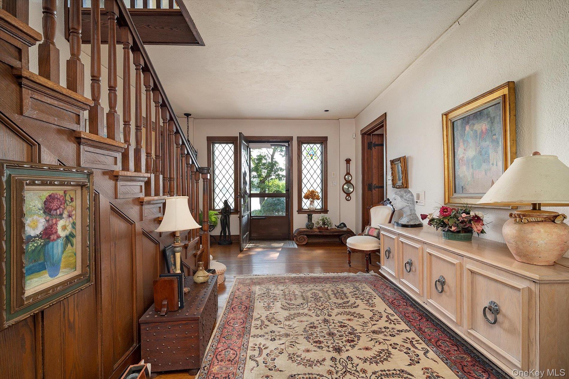 6 Shore Drive Great Neck, NY 11021 - Photo 5 of 10 Entryway with a textured ceiling, dark wood-type flooring, and stairway