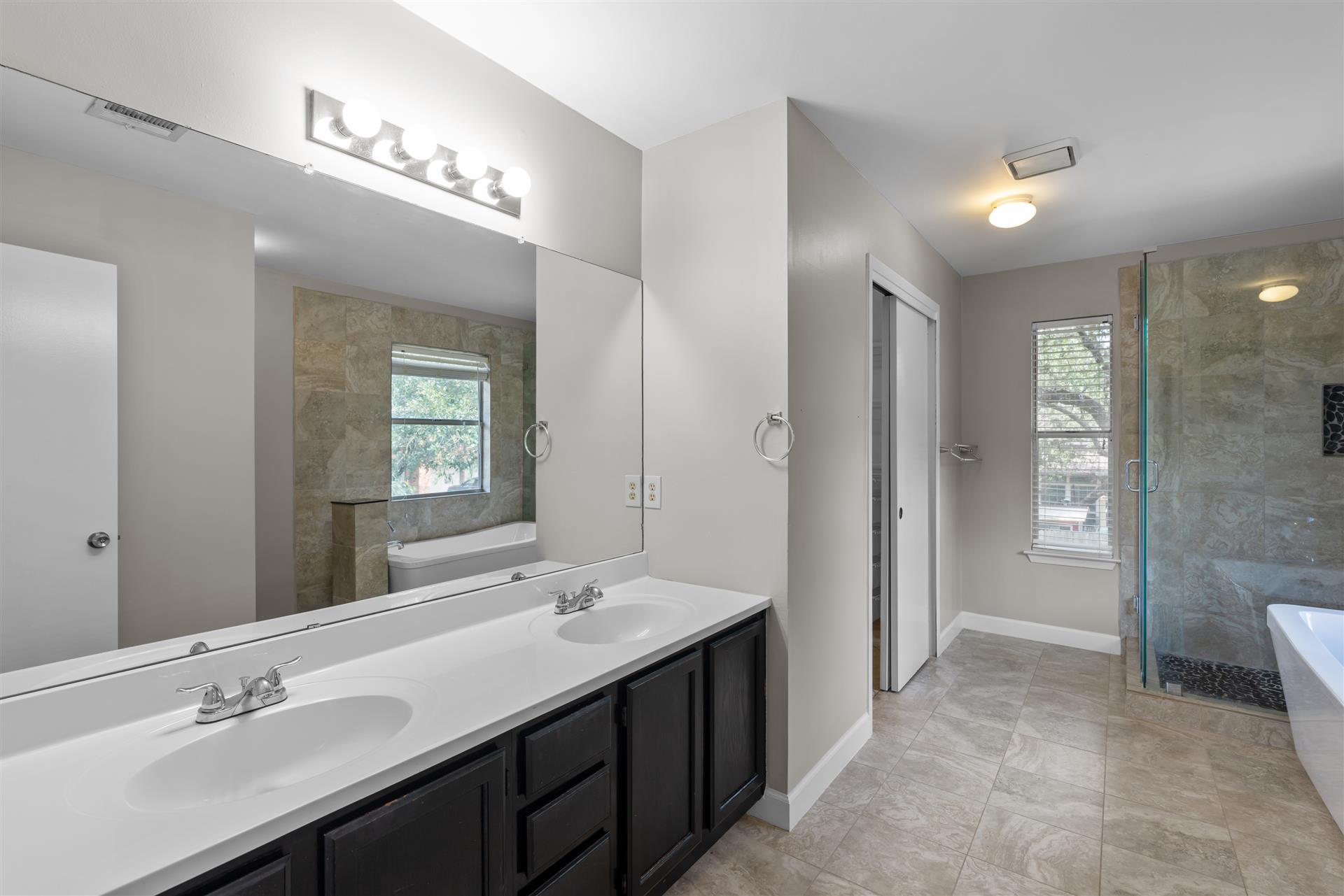 1710 Persimmon Road Cedar Park, TX 78613 - Photo 21 of 33 A well-appointed primary spa bathroom featuring a double vanity, a glass-enclosed shower, and a soaker tub.