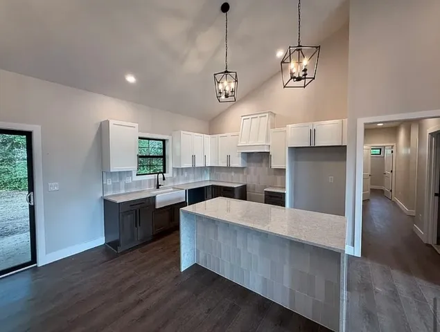 a large kitchen with stainless steel appliances a large counter top a refrigerator and a sink