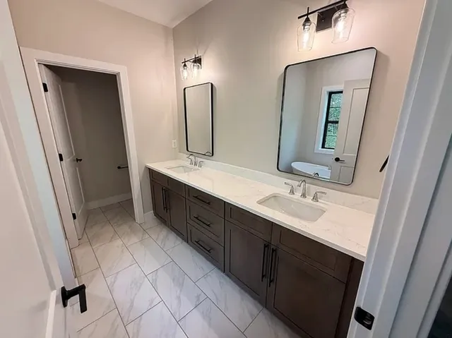 a bathroom with a double vanity sink mirror and