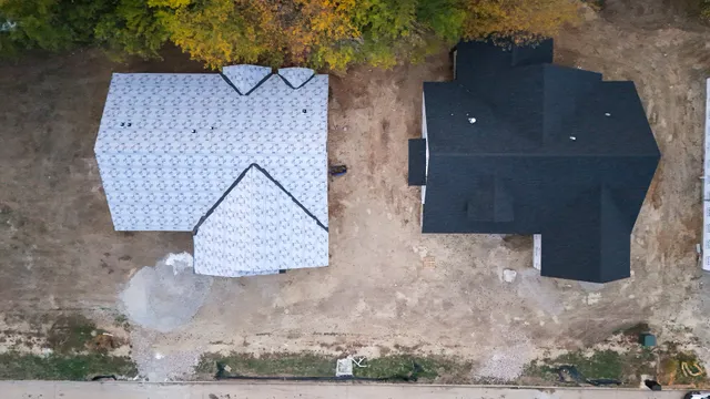 an aerial view of a house with a yard and wooden fence