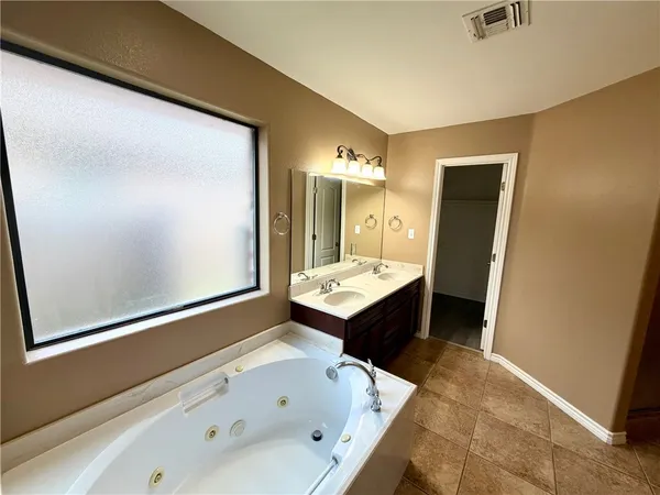 a bathroom with a tub sink and mirror