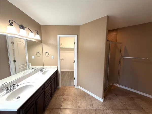 a spacious bathroom with a double vanity sink and a mirror