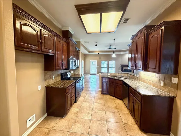 a large kitchen with stainless steel appliances granite countertop a sink stove and cabinets
