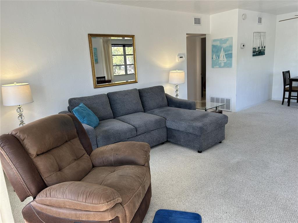 4154 57th Street North, Unit 274 Kenneth City, FL 33709 - Photo 2 of 28 a living room with furniture a couch and dresser