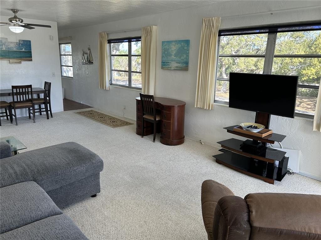 4154 57th Street North, Unit 274 Kenneth City, FL 33709 - Photo 3 of 28 a living room with furniture and a flat screen tv