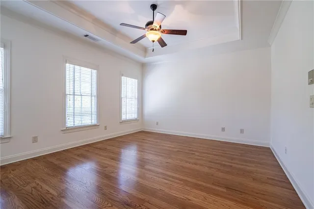 a view of an empty room with window and wooden floor