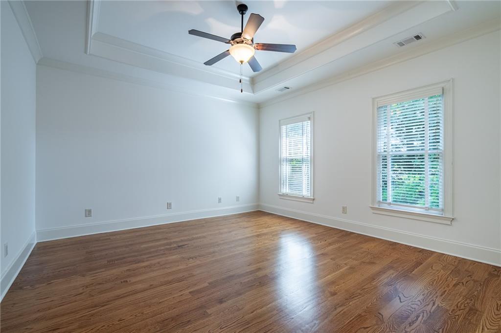 12 Candler Grove Drive Decatur, GA 30030 - Photo 23 of 33 an empty room with wooden floor chandelier fan and windows
