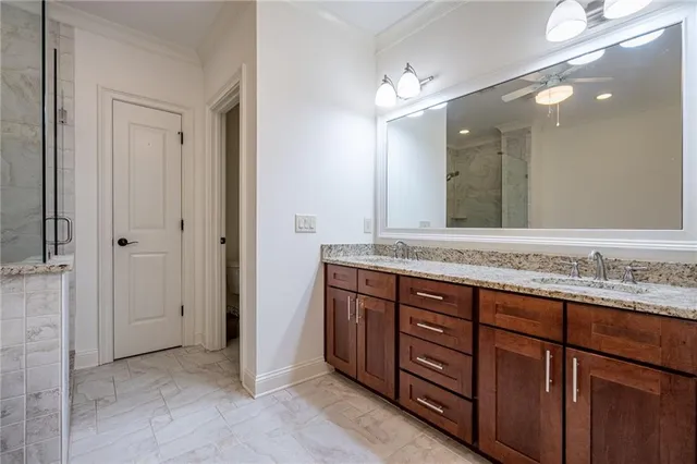 a bathroom with a granite countertop double vanity sink and a mirror