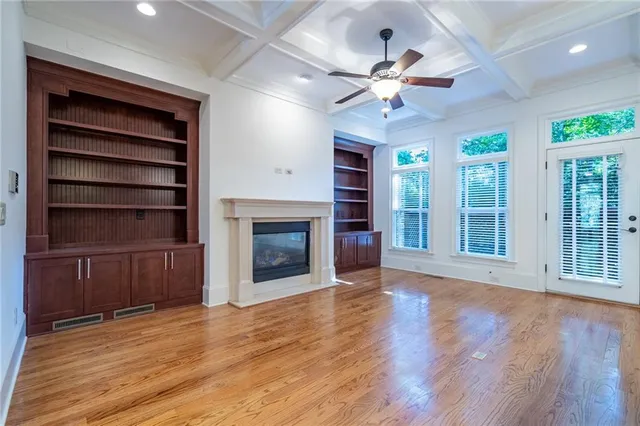 a view of an empty room with a fireplace and a window