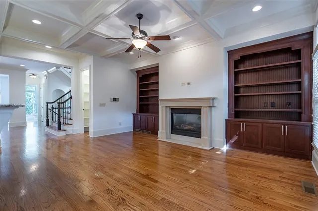 a view of a livingroom with a fireplace a chandelier and wooden floor