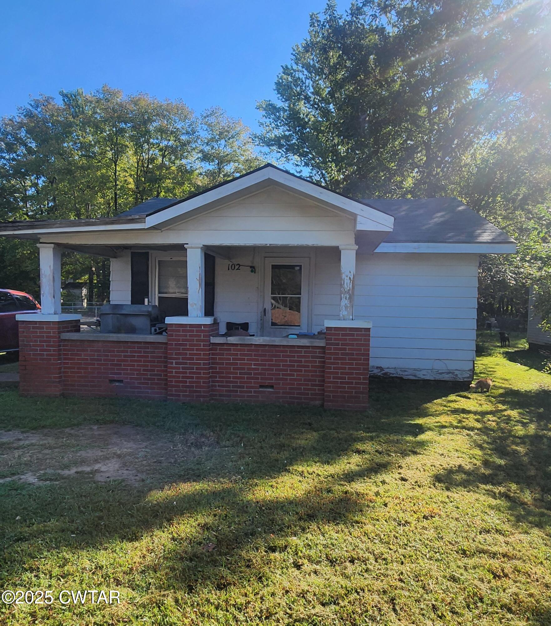 a view of a house with a yard porch and furniture