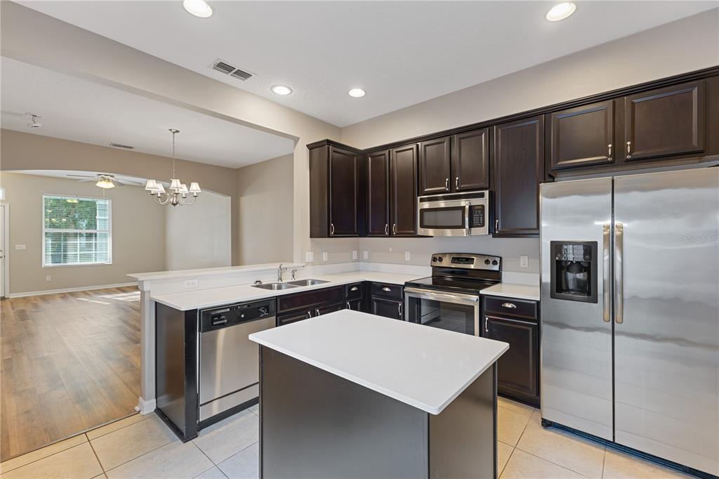 506 Rainbow Springs Loop Groveland, FL 34736 - Photo 9 of 30 a kitchen with stainless steel appliances granite countertop a sink stove and refrigerator