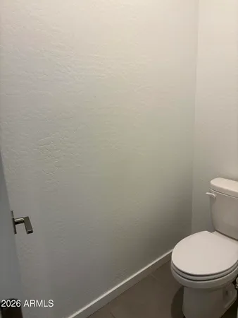 a white toilet sitting next to a white wall