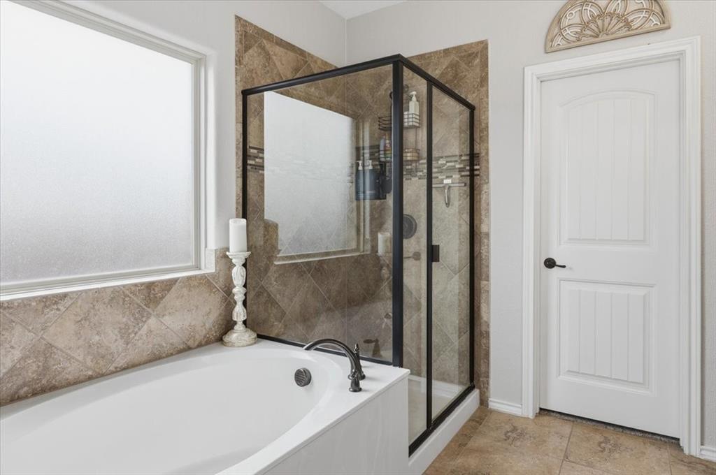 448 Spring Drive Saginaw, TX 76131 - Photo 28 of 40 a bathroom with a bathtub and a shower