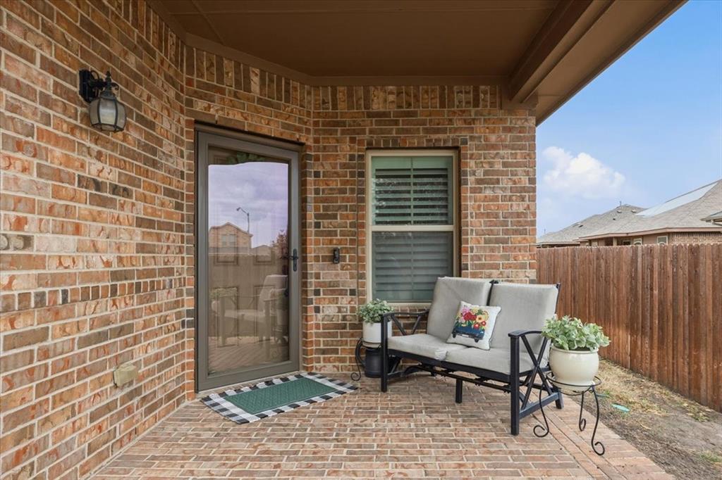 448 Spring Drive Saginaw, TX 76131 - Photo 5 of 40 a patio with table and chairs and potted plants