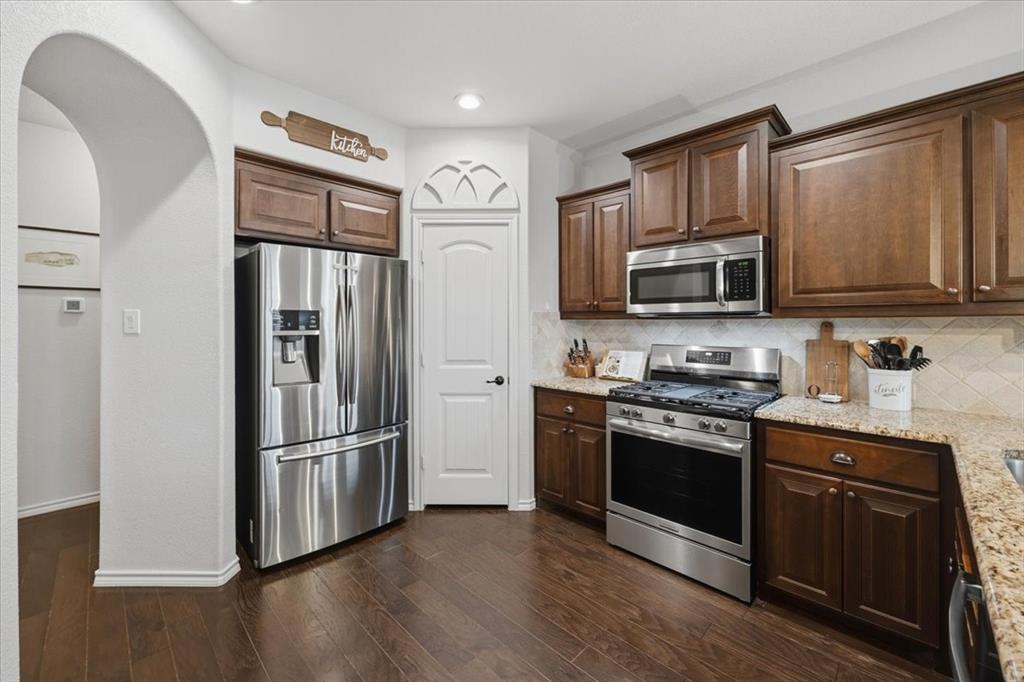448 Spring Drive Saginaw, TX 76131 - Photo 10 of 40 a kitchen with stainless steel appliances granite countertop a refrigerator stove and microwave