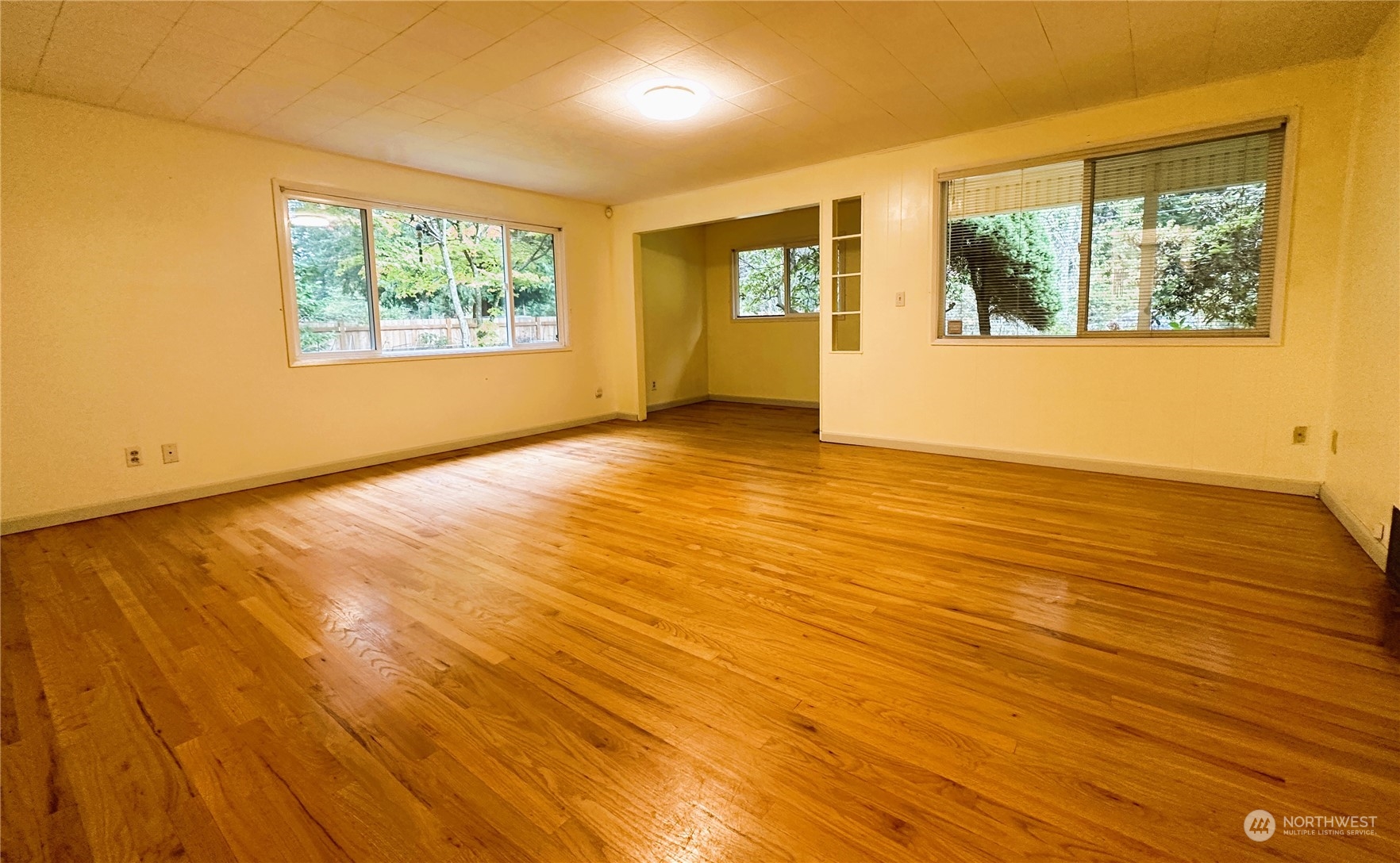 12429 Southeast 95th Way Renton, WA 98056 - Photo 10 of 15 a view of an empty room with wooden floor and a window