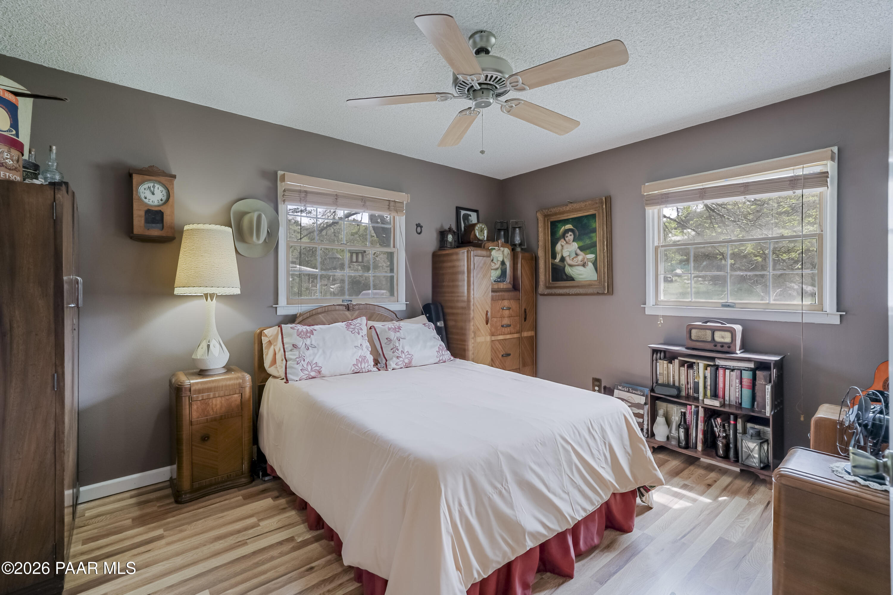 22584 Stone Way Yarnell, AZ 85362 - Photo 21 of 36 a bedroom with a large bed a chandelier and windows