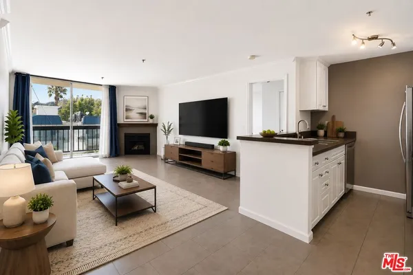 an empty room with kitchen view and a fireplace