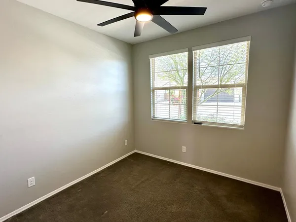 an empty room with a window and a fan