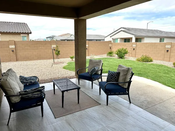 a view of a patio with lawn chairs couches and potted plants