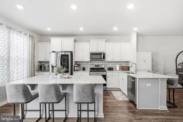 a kitchen with refrigerator a sink and chairs