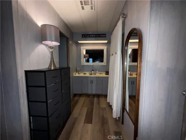 a spacious bedroom with a bed and wooden floor