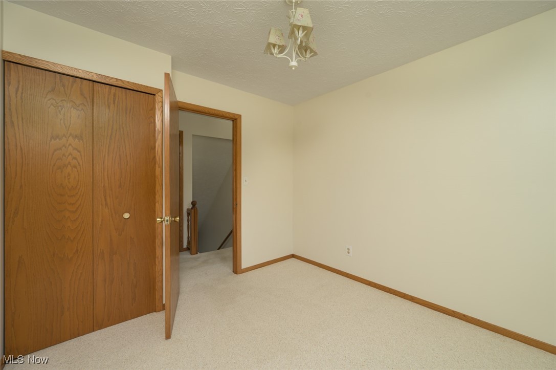 6600 Peck Road Ravenna, OH 44266 - Photo 23 of 50 Unfurnished bedroom featuring a closet, a textured ceiling, and light colored carpet