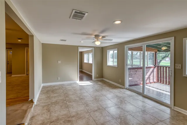 a view of an empty room with closet and a window