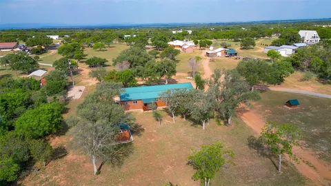 an aerial view of green landscape with trees houses and lake view