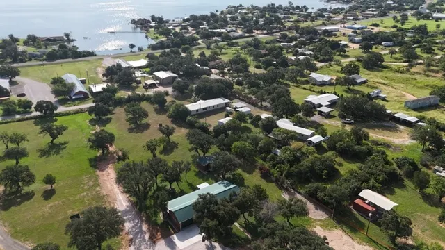 an aerial view of residential houses with outdoor space and trees