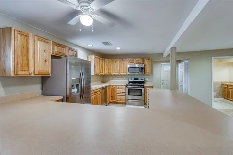 an empty room with a ceiling fan and a window
