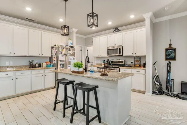 a kitchen with kitchen island granite countertop a table and chairs in it