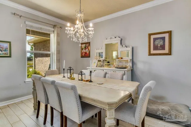 a view of a dining room with furniture a chandelier and wooden floor