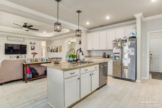 a kitchen that has a lot of cabinets a sink and appliances in it