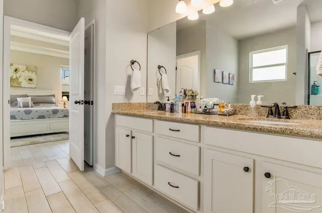 a bathroom with a granite countertop sink and a mirror