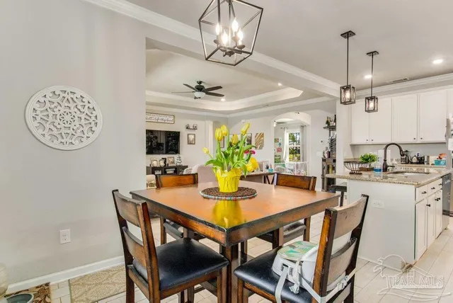 a view of a dining room with furniture a chandelier and wooden floor