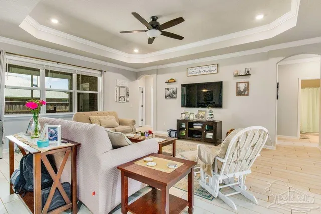 a living room with furniture a flat screen tv and a dining table with wooden floor