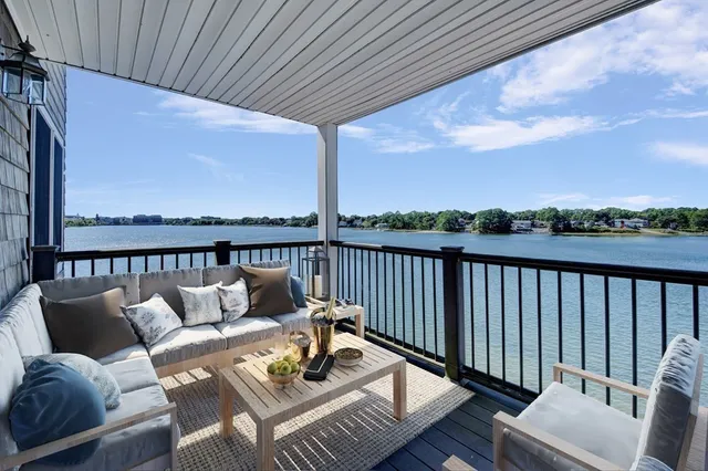 a balcony with wooden floor and outdoor seating